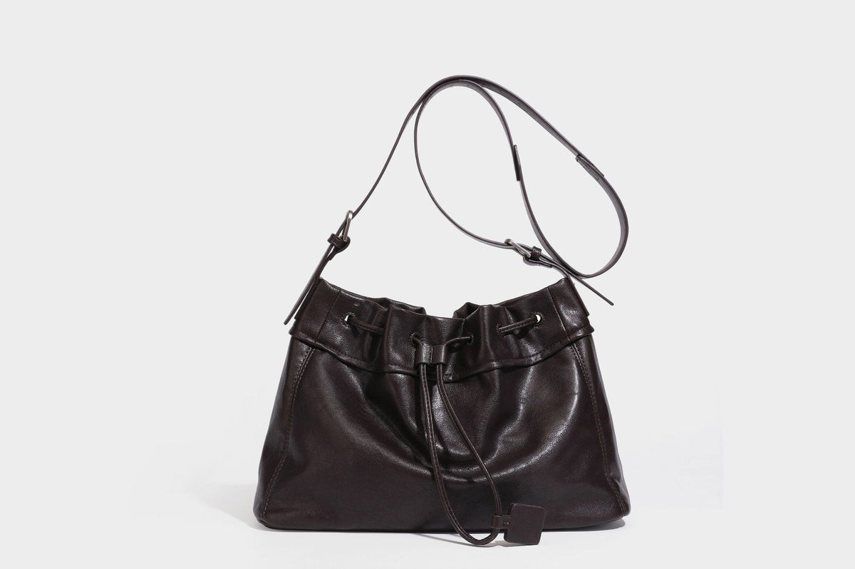 Lässig fallende Beuteltasche mit Kordelzug in dunkler Espresso-Lederoptik, verstellbarem Riemen und Ringbeschlägen aus Metall