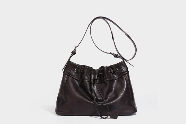 Lässig fallende Beuteltasche mit Kordelzug in dunkler Espresso-Lederoptik, verstellbarem Riemen und Ringbeschlägen aus Metall