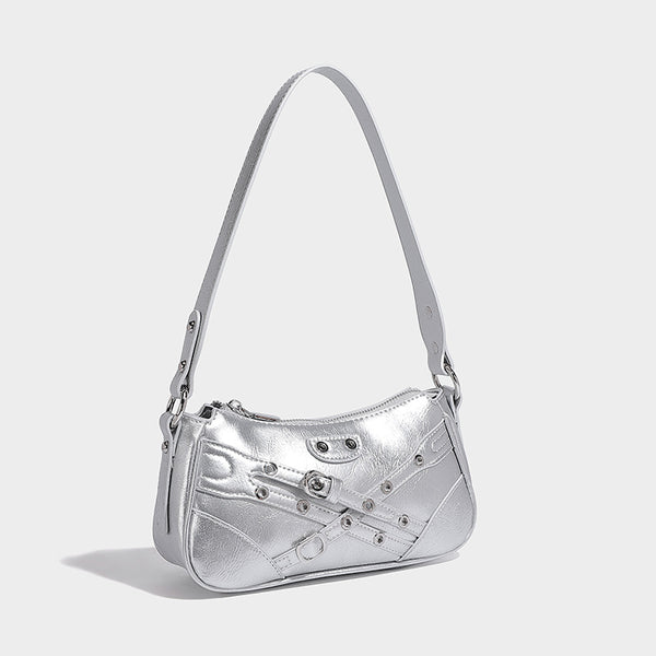 Compact moto-inspired shoulder bag with crisscross grommet strap detail, glossy textured finish, and adjustable crossbody
