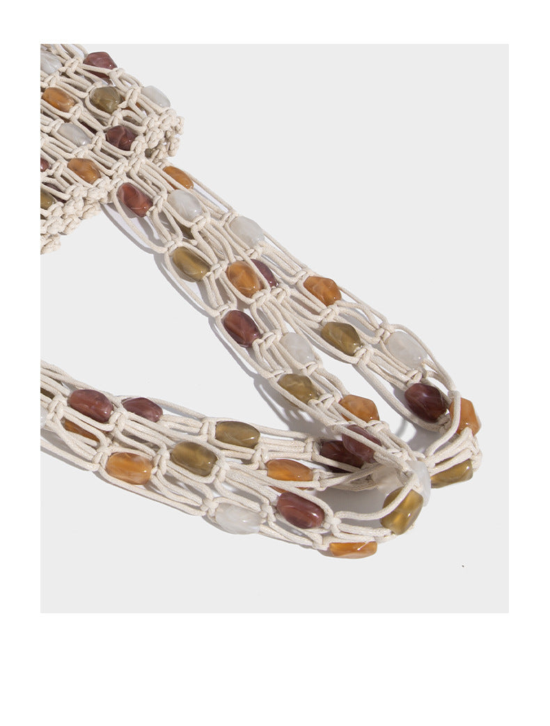 Cream macramé open-weave tote bag with multicolor amber olive and translucent bead accents and woven shoulder straps, detail