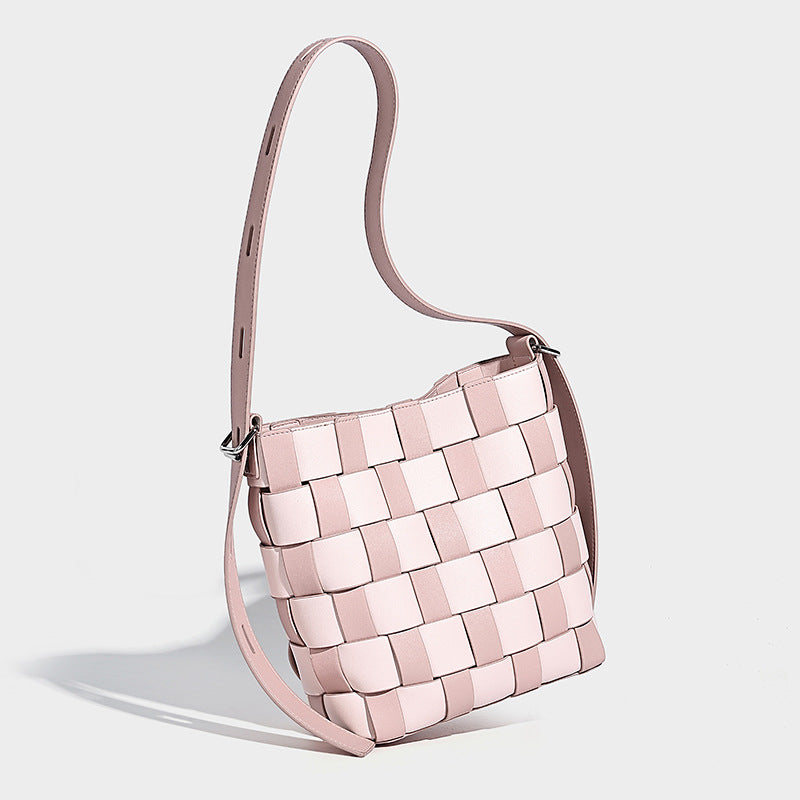 Hand-woven black-and-white checkerboard bucket bag with smooth black trim, silver-tone ring hardware, and adjustable