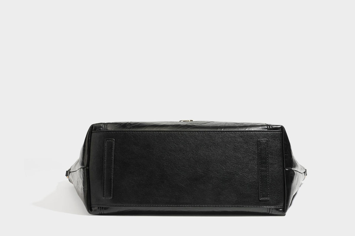Große, glänzende Tote-Bag aus schwarzem Lederimitat mit geknitterter Optik, lässig fallender Trapezsilhouette, zwei Schulterriemen und goldfarbenen