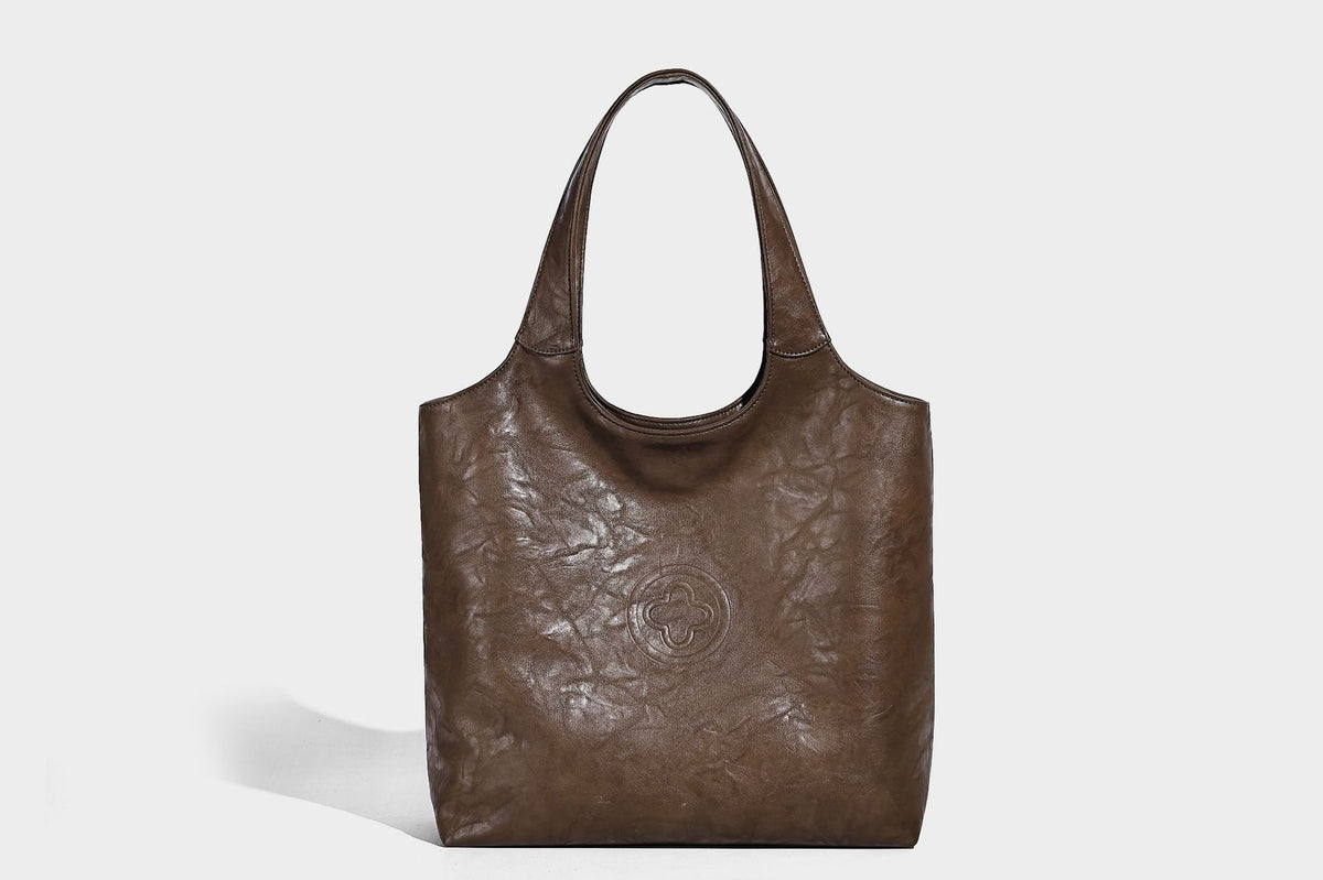 Large open-top tote bag with crinkled leather-look finish, long double shoulder straps, and embossed circular detail on