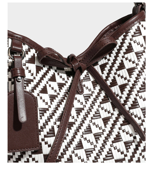 Woven geometric bucket shoulder bag in white and dark brown two-tone pattern with leather-look trim and drawstring top