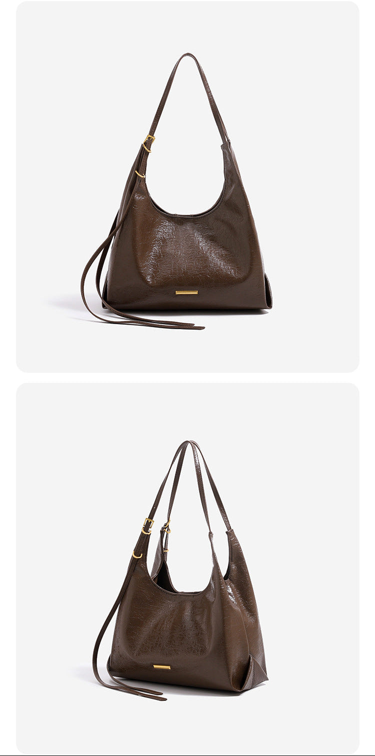 Slouchy hobo shoulder bag in crinkle high-gloss leather-look finish with gold-tone bar hardware and adjustable strap, detail