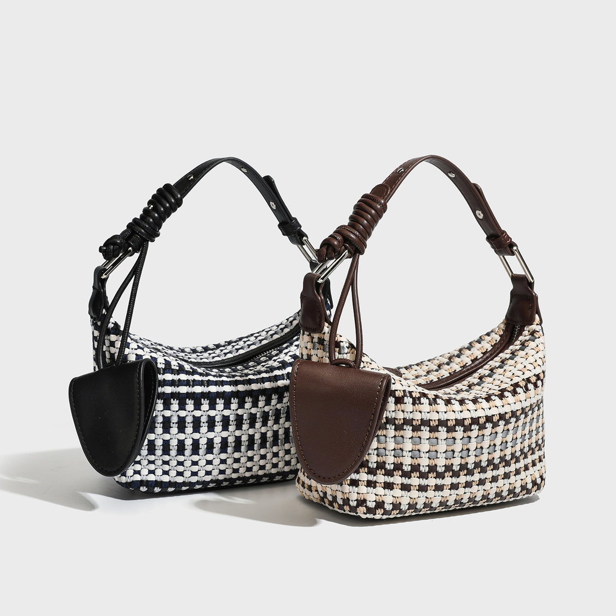 Kleine, sichelförmige Schultertasche aus schwarz-weißem Webtextil mit glattem schwarzem Kunstlederbesatz, Reißverschluss oben, geknotetem