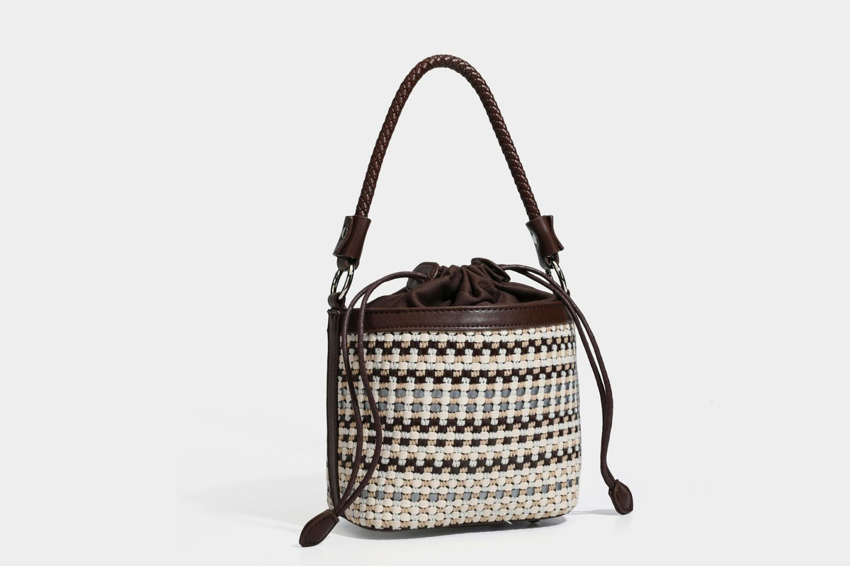 Small structured woven checker bucket bag with braided top handle, drawstring closure, and silver-tone hardware in black