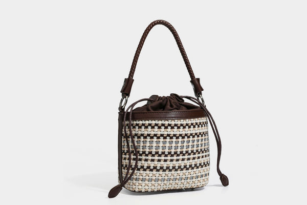 Small structured woven checker bucket bag with braided top handle, drawstring closure, and silver-tone hardware in black