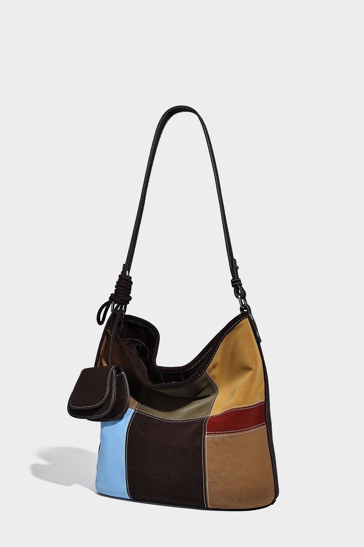 Weich fallende Patchwork-Bucket-Schultertasche mit Einsätzen in Dunkelbraun, Cognac, Senfgelb, Olivgrün, Rot und Hellblau sowie Kontrastnähten