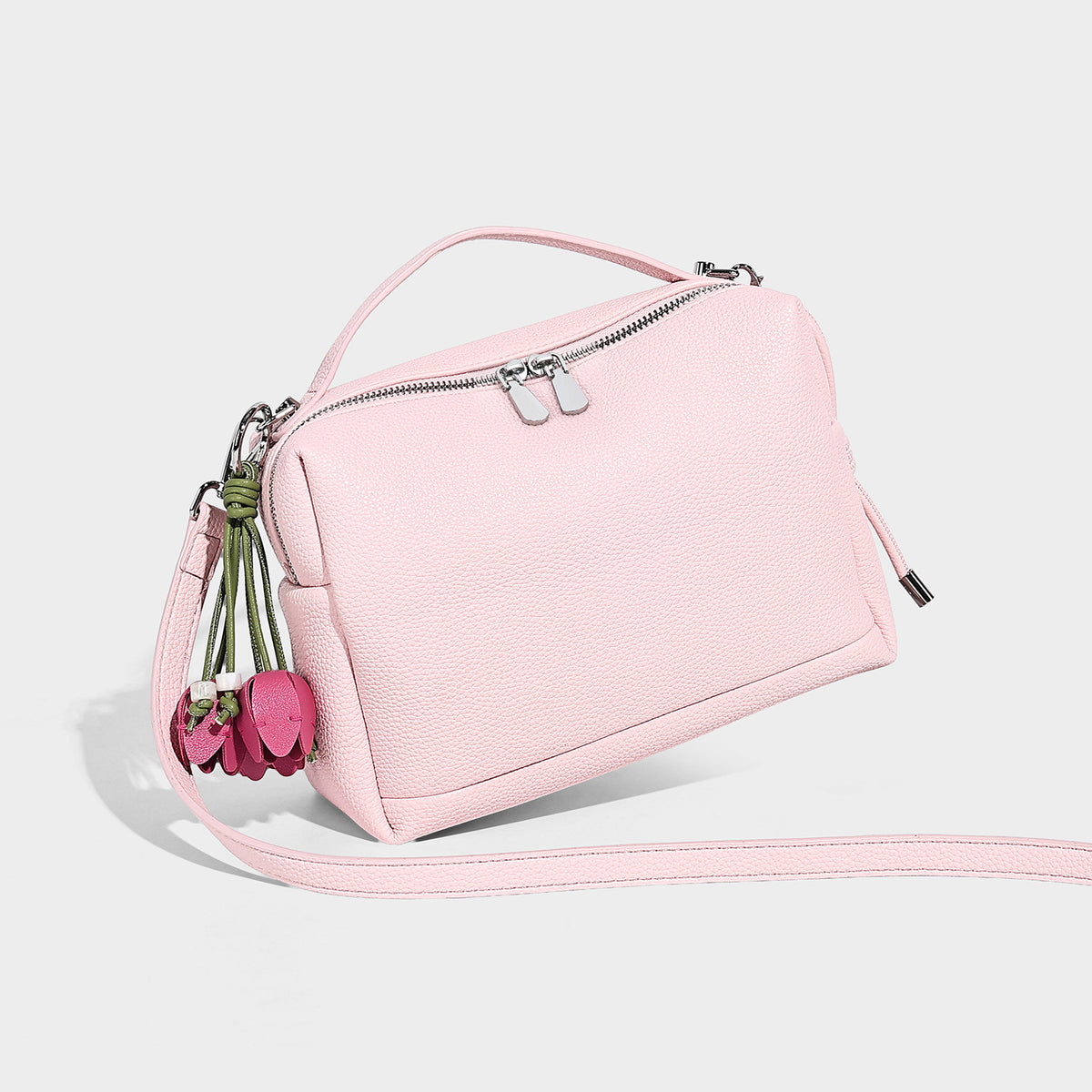 Small structured pebbled top-handle crossbody bag with zip closure, silver-tone hardware, and optional hanging tassel charm