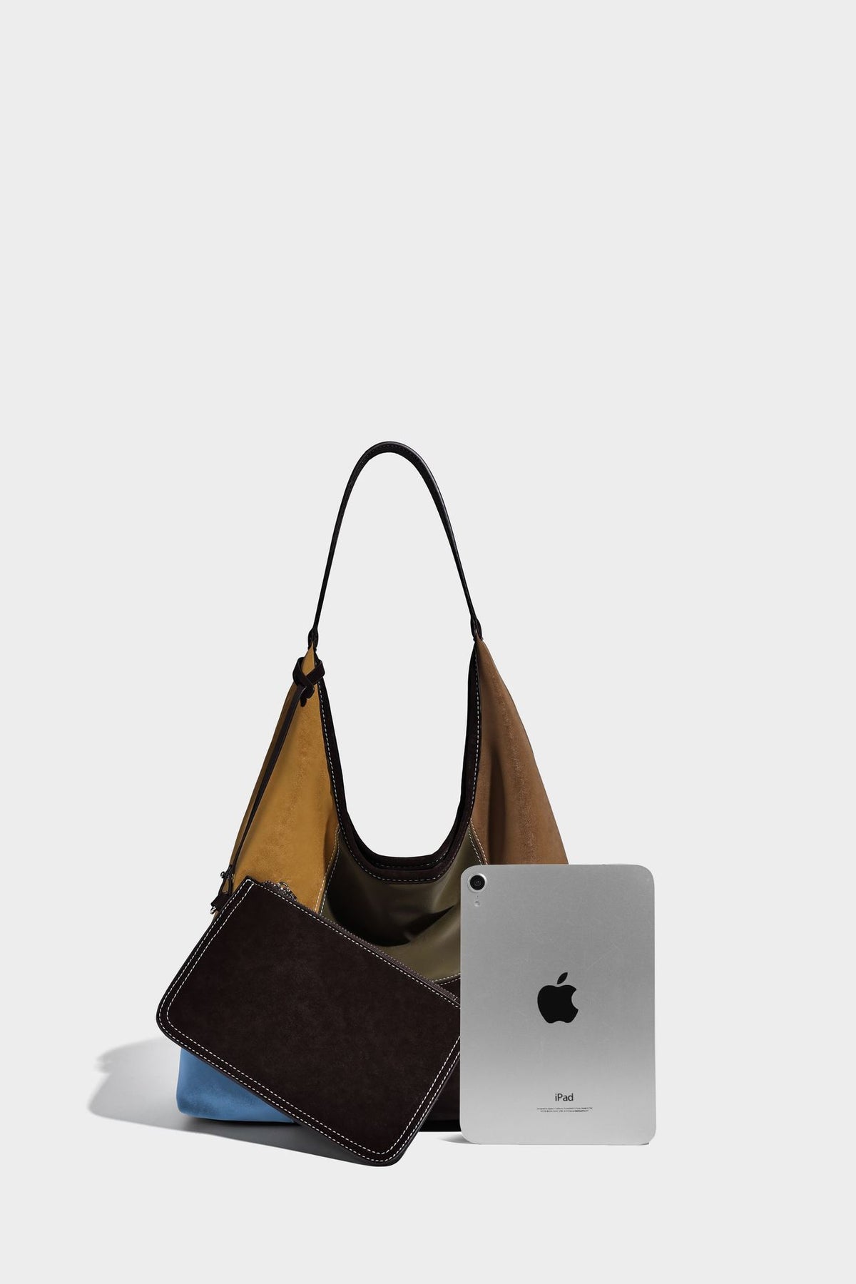Multicolor patchwork hobo shoulder bag with brown tan olive mustard red and blue suede-look panels, contrast white stitching