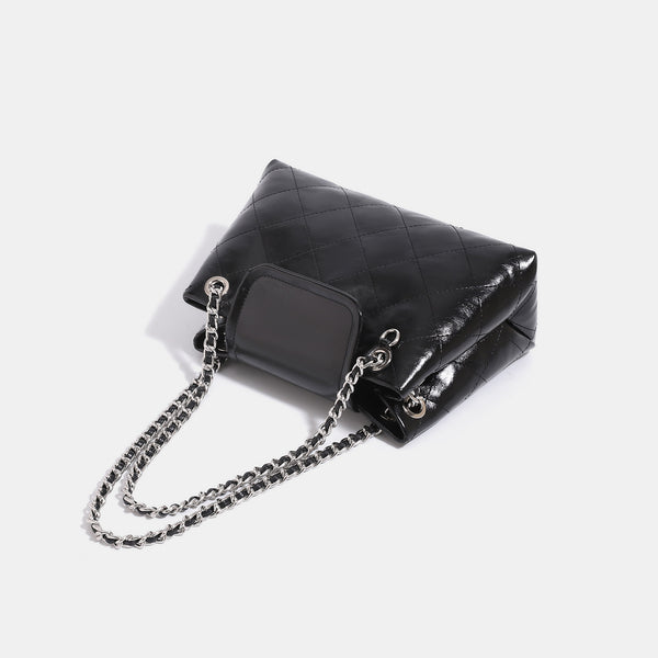 Quilted trapezoid shoulder bag with chain straps, flap closure, and ring hardware, detail view 4