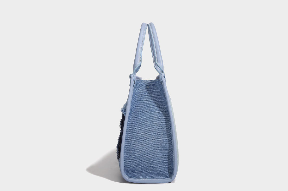 Structured patchwork denim tote bag with frayed panel seams, dual top handles, and silver-tone hardware, detail view 13