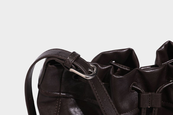 Lässig fallende Beuteltasche mit Kordelzug in dunkler Espresso-Lederoptik, verstellbarem Riemen und Ringbeschlägen aus Metall