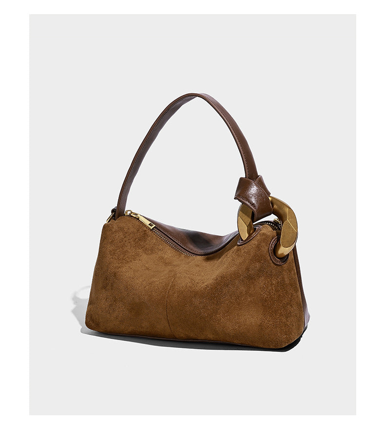 Kompakte Boston-Schultertasche in warmer Braunfarbe mit Wildlederoptik, glatten dunkelbraunen Besätzen, übergroßen goldfarbenen Ringbeschlägen und Reißverschluss oben