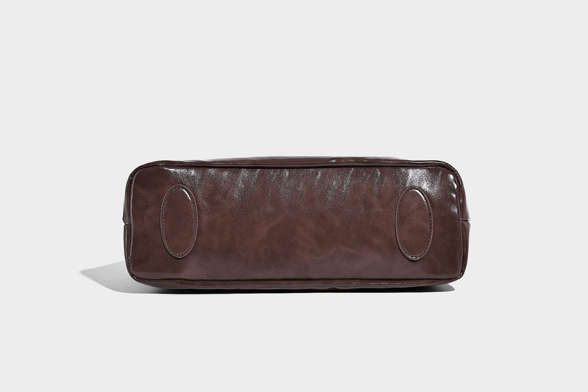 Glossy slouchy hobo shoulder bag with adjustable strap and embossed floral emblem, detail view 22