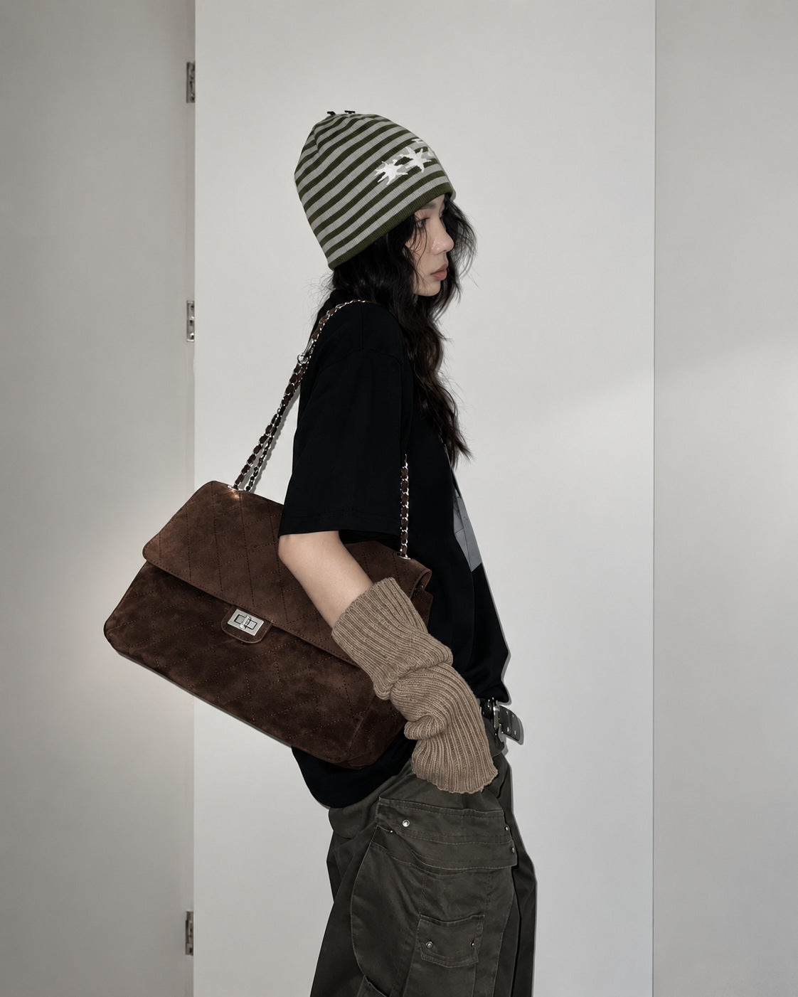 Quilted diamond-stitch flap shoulder bag with double silver chain strap and turn-lock closure in suede-look finish, detail