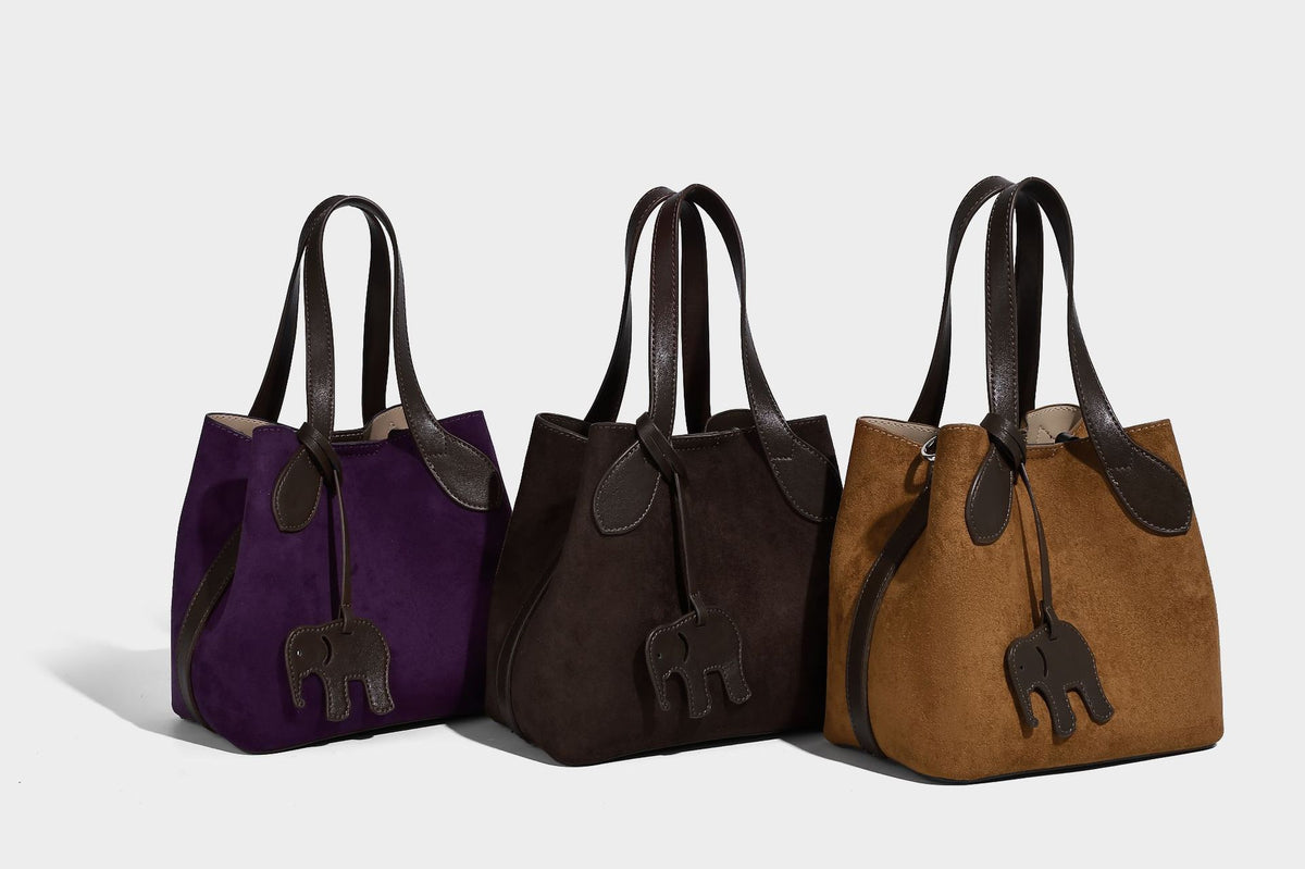 Kleine strukturierte Handtasche in Velourslederoptik mit Elefanten-Anhänger, zwei Henkeln und abnehmbarem Umhängegurt, Detailansicht