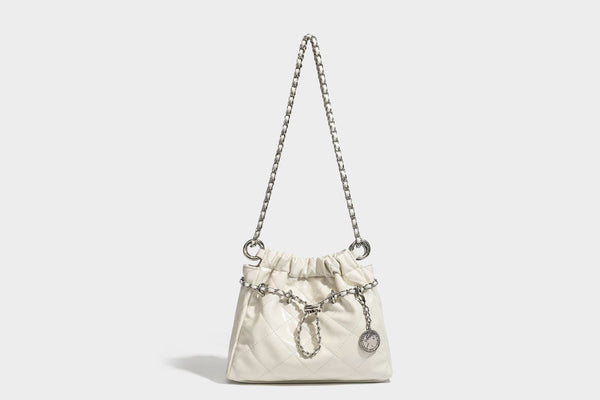 Glossy diamond-quilted drawstring bucket bag with silver chain shoulder strap and medallion charm, detail view 22