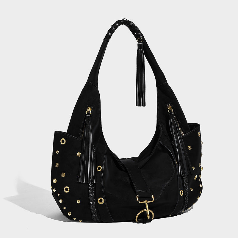 Slouchy crescent hobo bag in matte brown suede-like finish with gold-tone studs, grommets, braided top handle, tassel side