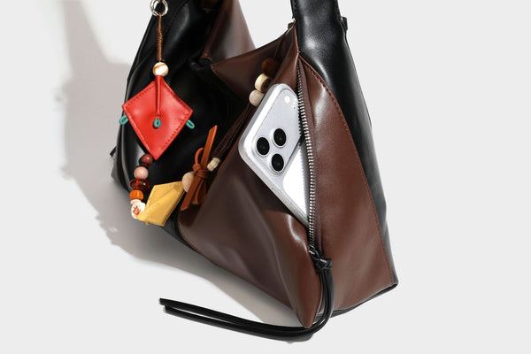 Two-tone black and brown leather-look slouchy shoulder bag with beaded tassel charm and silver-tone hardware, detail view 29