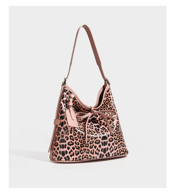 Slouchy leopard print shoulder hobo bag with black leather-look trim, tie-top closure, and single long strap, detail view 14
