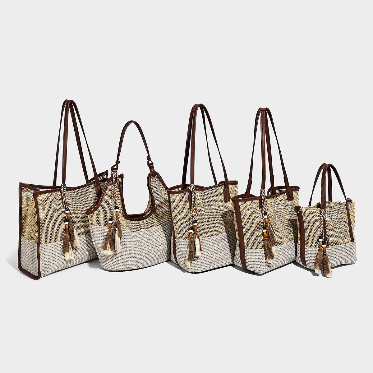 Large open-weave straw tote bag in tan and cream with dark brown leather-look trim, long shoulder straps, and a beaded