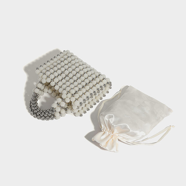 Small boxy pearl-bead mini top-handle bag with silver metallic bead accents, satin floral detail, and long beaded shoulder