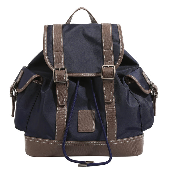 Deep navy canvas backpack with brown textured leather-look trim, drawstring flap closure, buckle-strap front detail, and