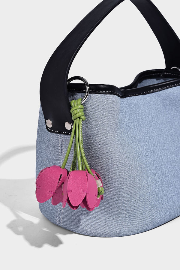 Hellblaue Bucket-Bag aus Denim mit schwarzem Besatz in Lederoptik, silberfarbenen Beschlägen, kurzem Tragegriff und langem verstellbarem Crossbody-Riemen