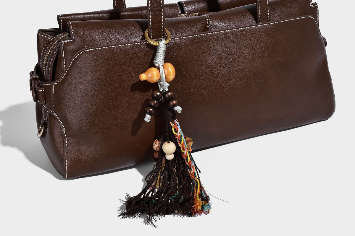 Strukturierte rechteckige Baguette-Schultertasche aus dunkelbraunem Material in glatter Lederoptik mit zwei Riemen und Reißverschluss oben
