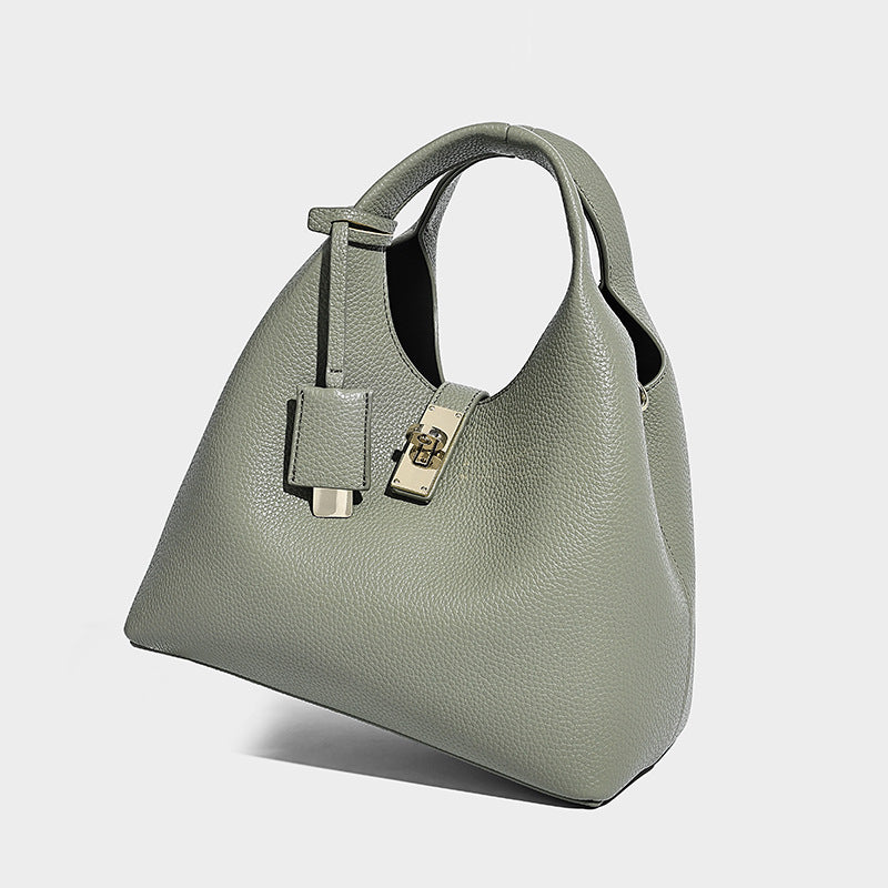 Structured pebbled-texture bucket bag with arched top handles, gold-tone turn-lock closure, and detachable shoulder strap