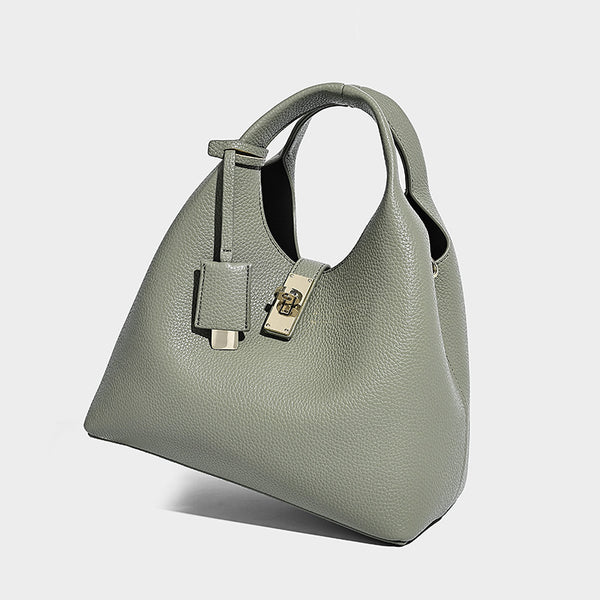 Structured pebbled-texture bucket bag with arched top handles, gold-tone turn-lock closure, and detachable shoulder strap