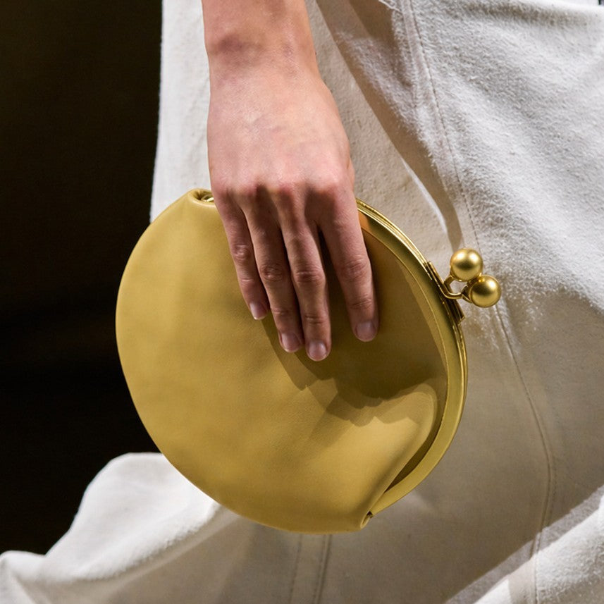 Round kiss-lock clutch bag with gold-toned frame and ball knobs, detail view 2