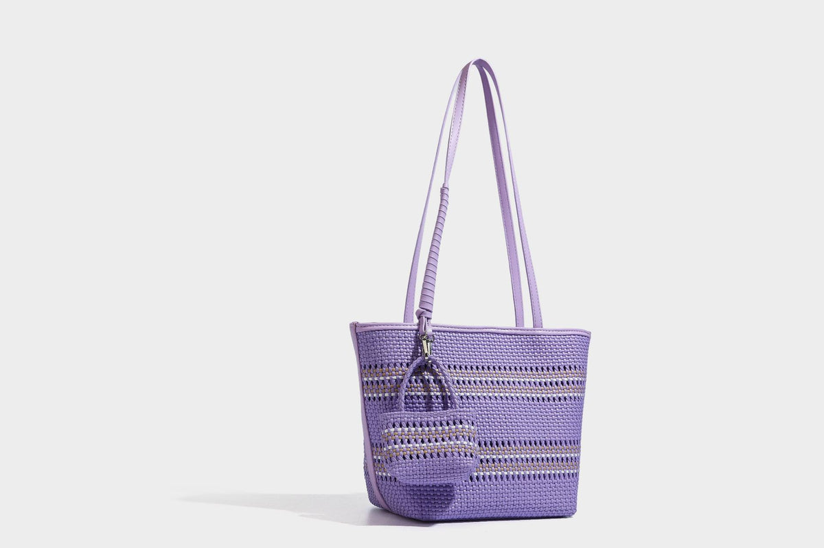 Large structured woven tote bag with striped basket-weave finish, long shoulder straps, and detachable mini pouch charm
