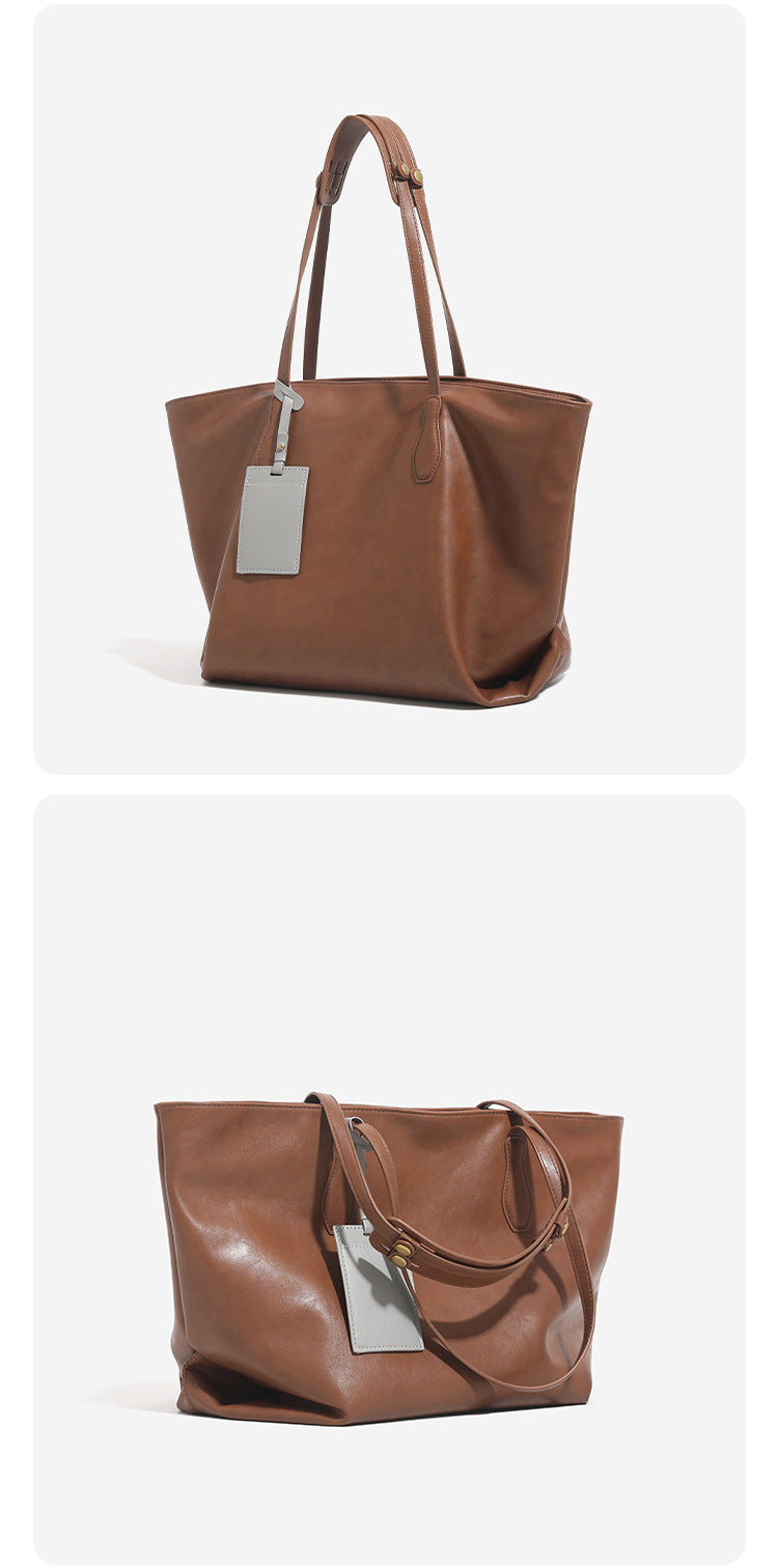 Large leather-look tote bag with trapezoid silhouette, double shoulder straps, and detachable hanging tag, detail view 10