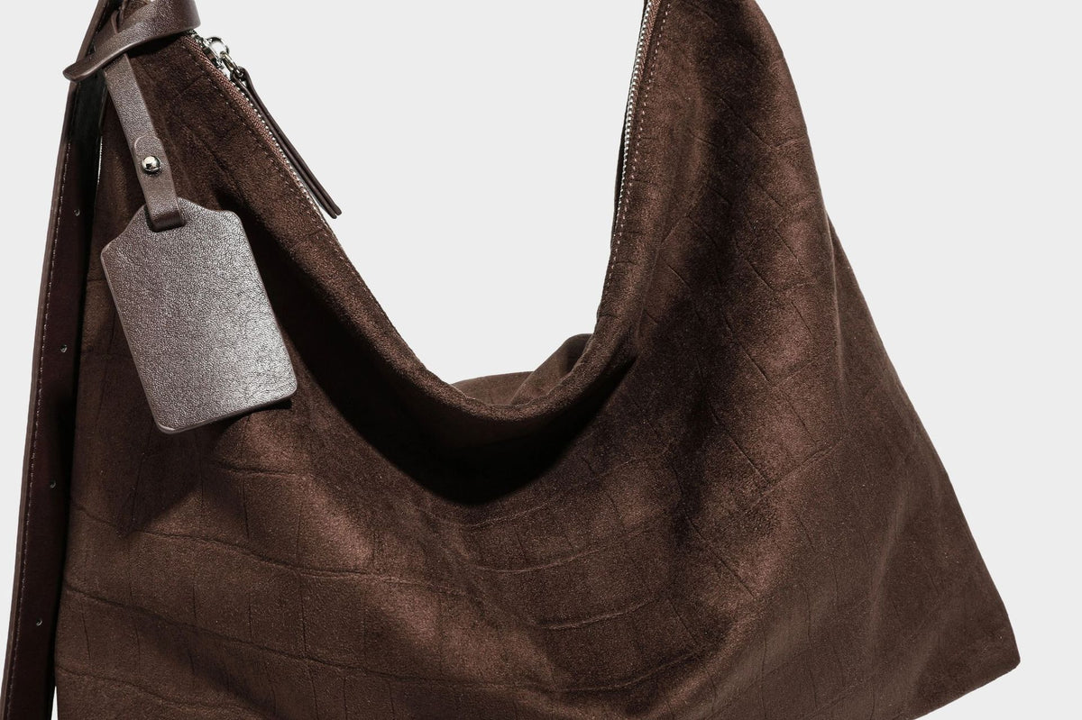 Slouchy hobo shoulder bag in matte croc-embossed leather-look finish with top zip closure and long adjustable strap, detail