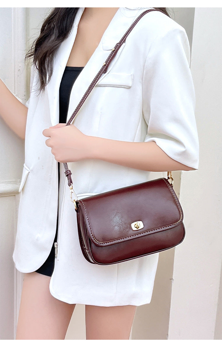 Kleine strukturierte Crossbody-Tasche mit Überschlag in glänzender Lederoptik, goldfarbenem Drehverschluss und verstellbarem Riemen