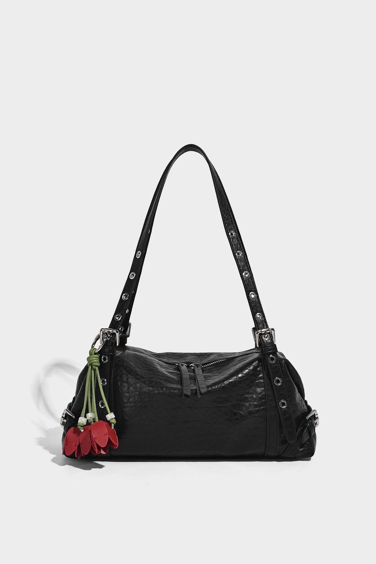Pale yellow leather-look barrel bag with silver grommet-studded shoulder straps, top zip closure, and pink tulip floral