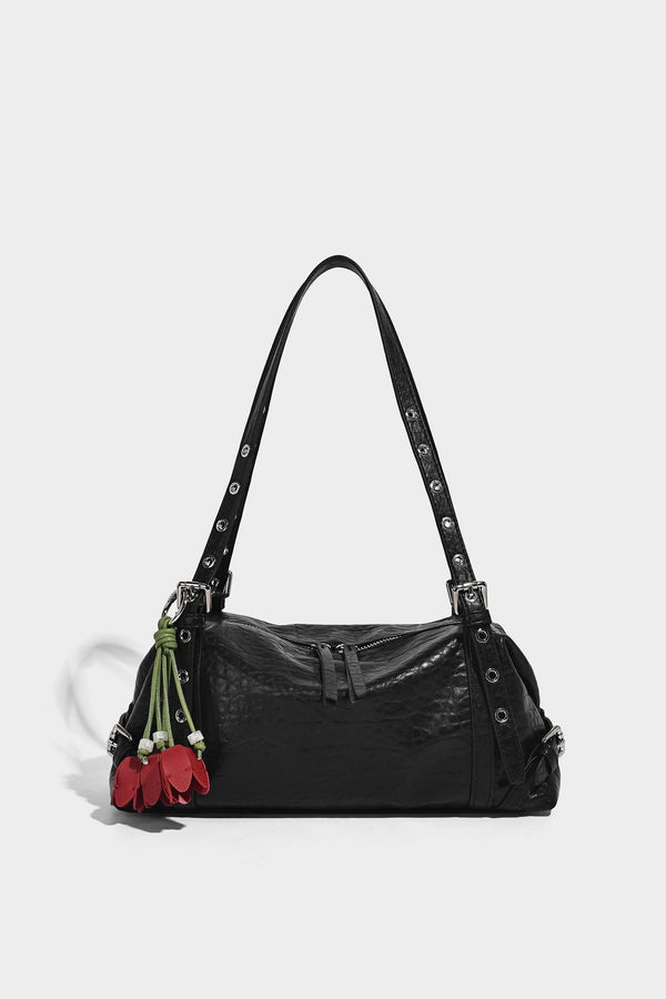Pale yellow leather-look barrel bag with silver grommet-studded shoulder straps, top zip closure, and pink tulip floral