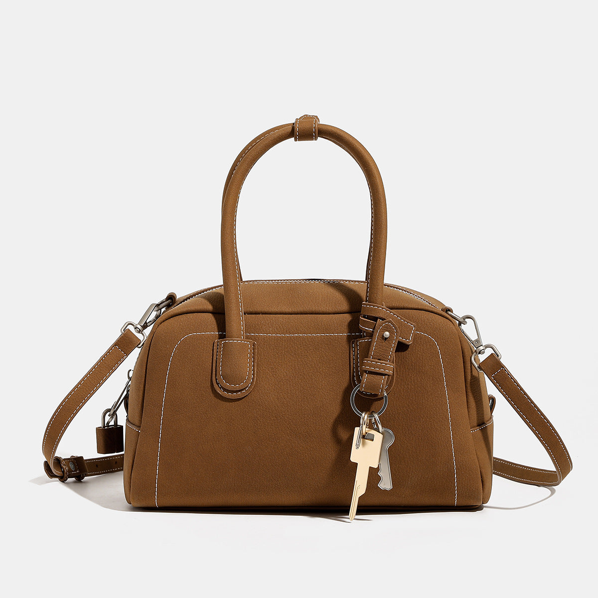 Kompakte, strukturierte Henkeltasche mit matter genarbter Oberfläche, geknoteten Doppelgriffen, goldenem Schlüsselanhänger und abnehmbarem, Detailansicht
