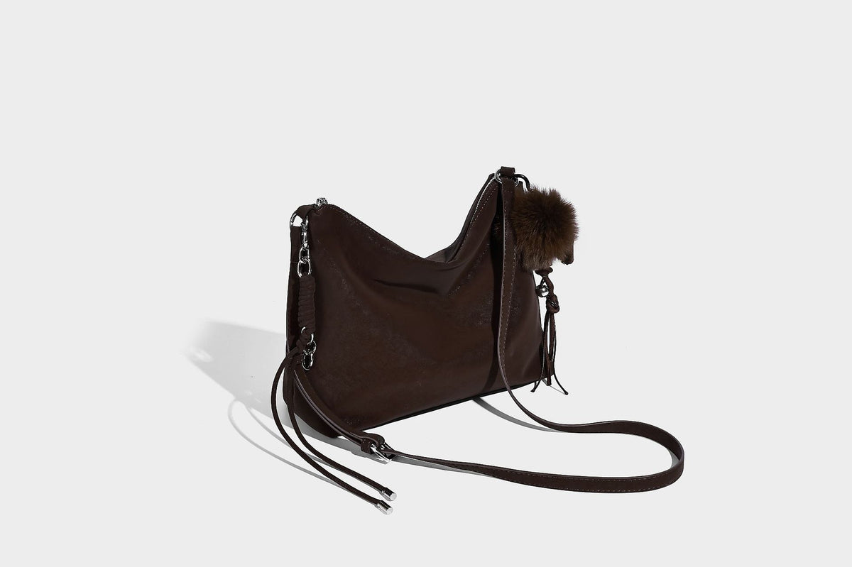 Slouchy matte-finish hobo shoulder bag with tassel cords, silver-tone hardware, and faux-fur pom charm, detail view 16