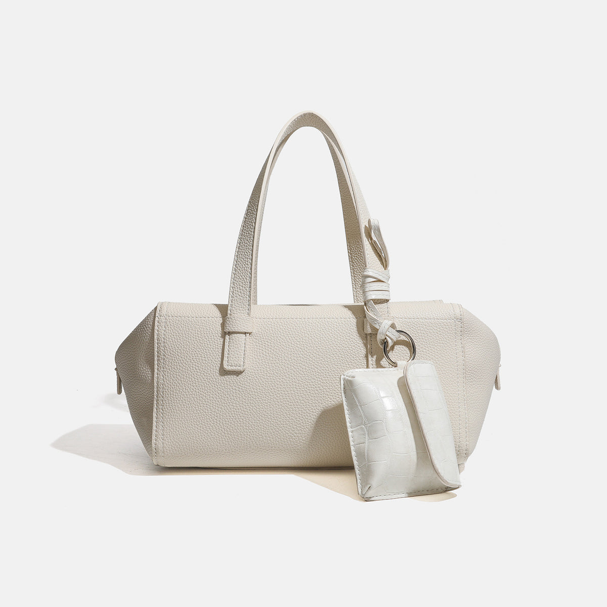 Structured pebbled leather-look top-zip barrel bag with dual handles, detachable shoulder strap, and attached croc-pattern