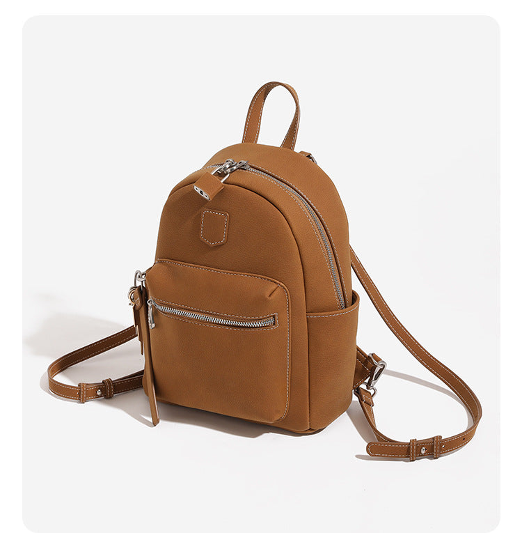 Mini-Rucksackhandtasche mit abgerundeter Form und genarbter Oberfläche, silberfarbenen Beschlägen, Reißverschlussfach vorne und verstellbaren Rucksackriemen