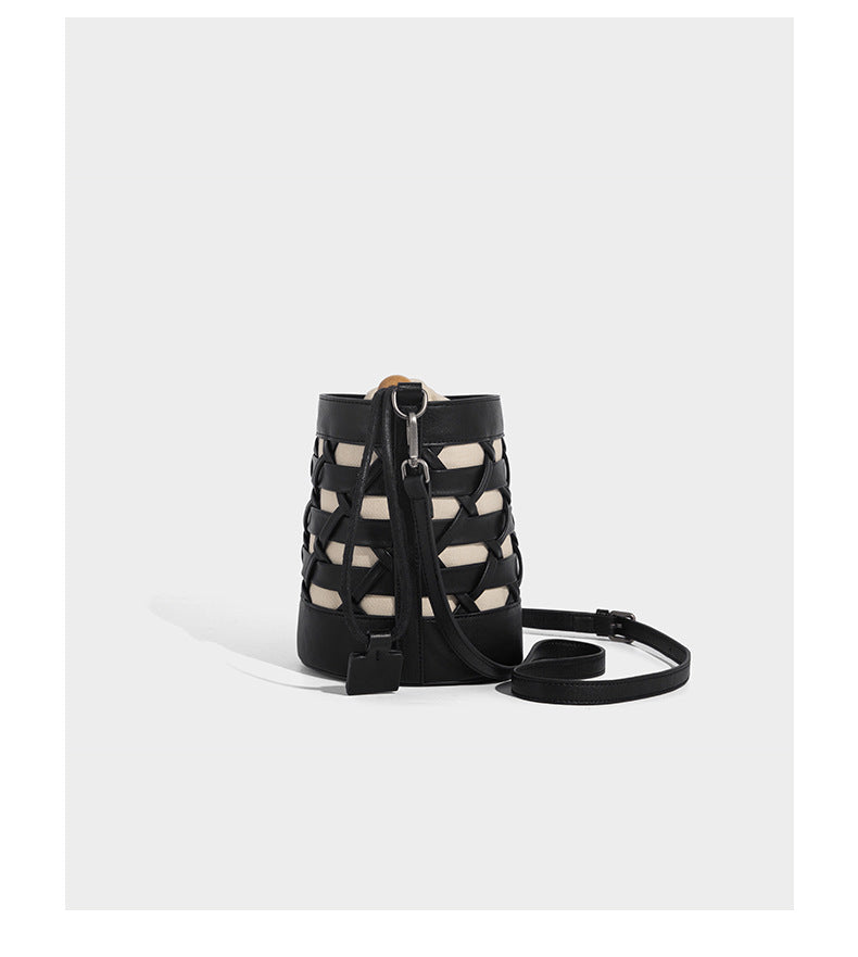 Small cylindrical woven lattice bucket bag with leather-look black trim, beige canvas body, wooden bead drawstring closure