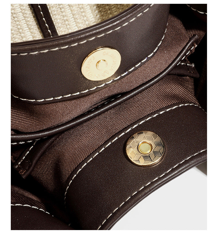 Cremefarbene geflochtene Tote-Bag mit dunkelbraunen Besätzen in Lederoptik, kontrastierenden weißen Nähten, zwei oberen Henkeln und abnehmbarem Schulter