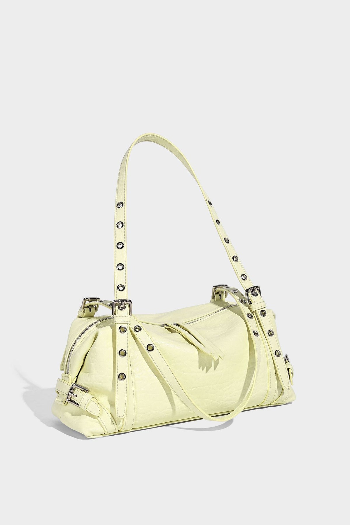 Pale yellow leather-look barrel bag with silver grommet-studded shoulder straps, top zip closure, and pink tulip floral