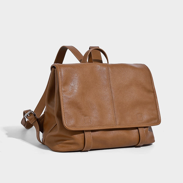 Structured tan leather-look flap backpack handbag with top handle, silver buckle hardware, and fold-over front closure, front