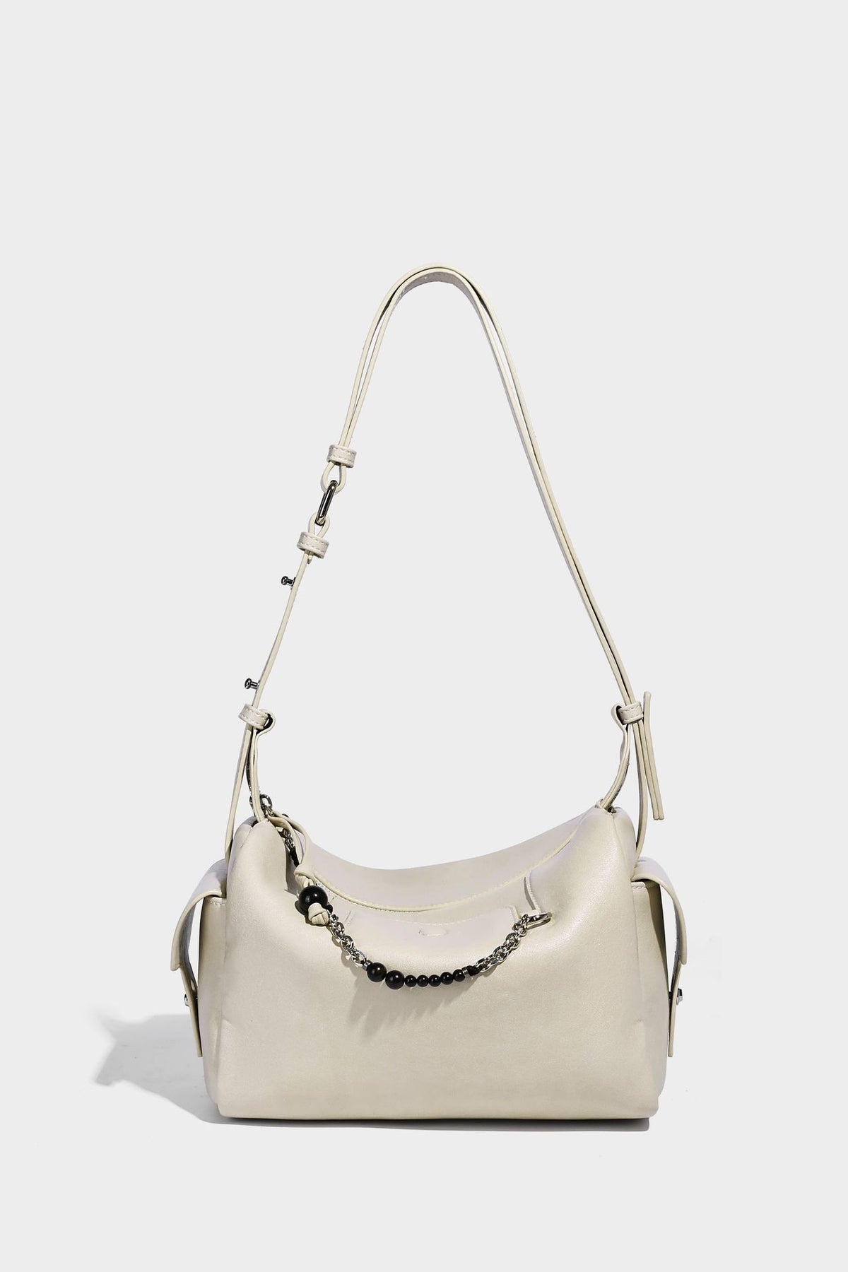 Small slouchy moto-style crossbody bag in smooth matte leather-look finish with white contrast stitching, silver-tone, detail