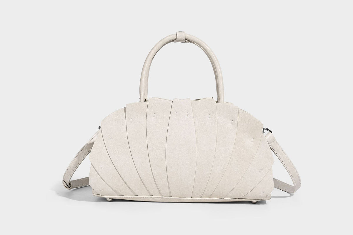 Structured dome satchel with fan-pleated leather-look exterior, dual top handles, and detachable shoulder strap, detail view